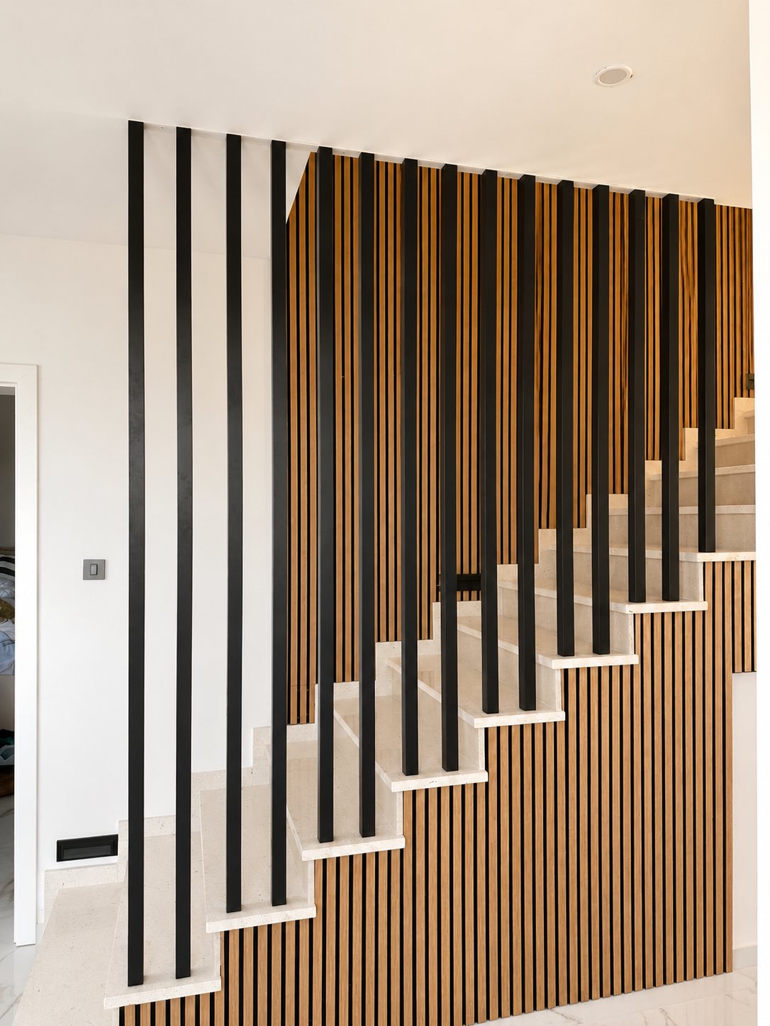 Separador decorativo de lamas verticales negras en escalera interior